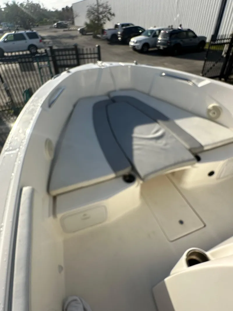 Slide: The Image of 2015 Striper 200 Center Console boat with spacious seating and storage, parked outdoors. - 8