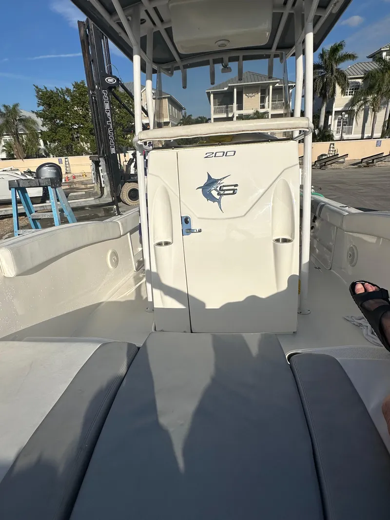 Slide: The Image of 2015 Striper 200 Center Console boat docked, featuring spacious seating and sleek design. - 9