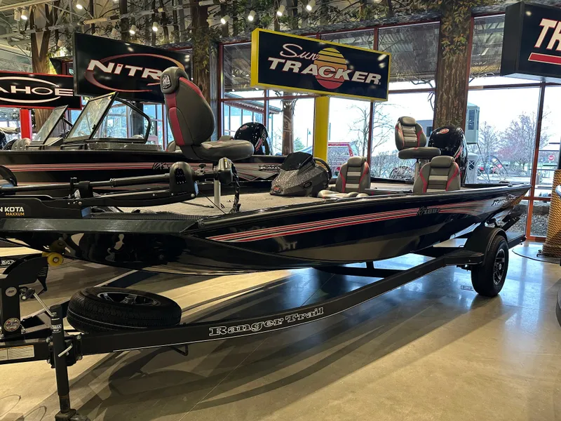 Slide: The Image of 2024 Ranger RT188P fishing boat displayed in showroom with other boats. - 0
