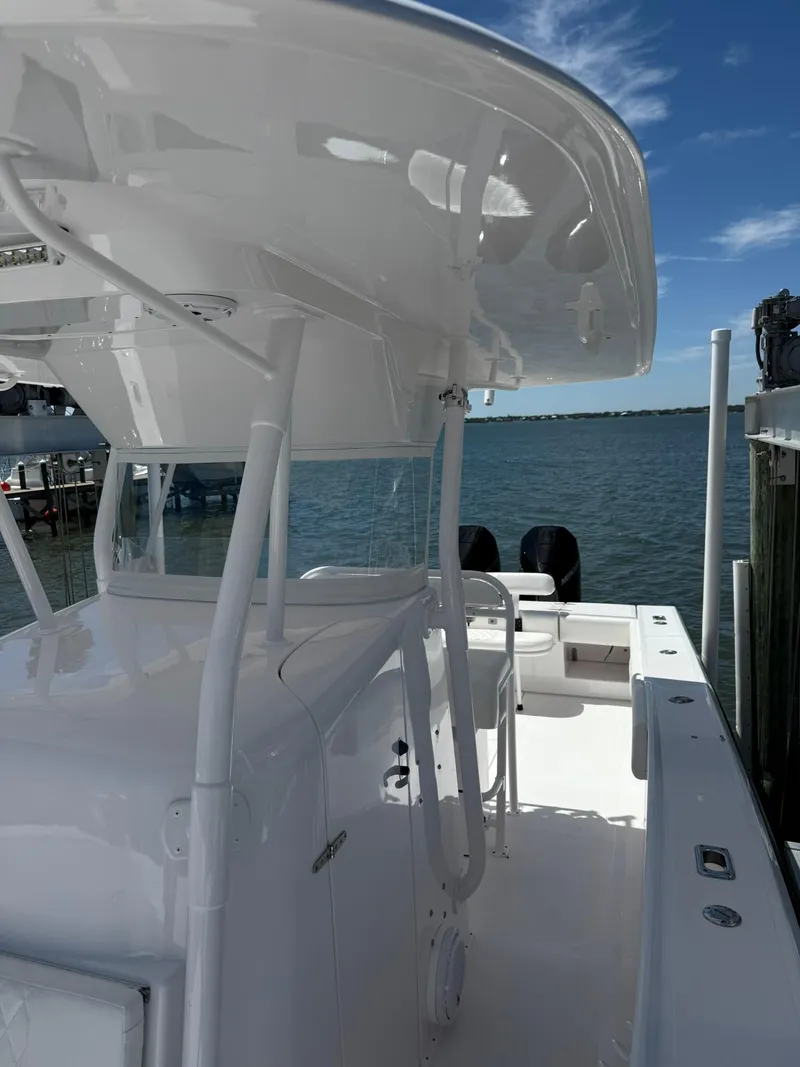 Slide: The Image of 1998 Venture Center Console boat docked by the water, featuring a sleek white design. - 4