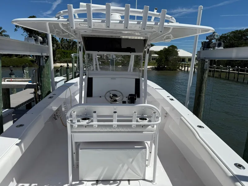 Slide: The Image of 1998 Venture Center Console boat docked, featuring a spacious deck and fishing rod holders. - 5