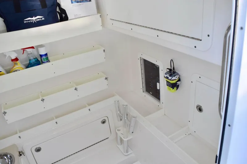 Slide: The Image of 2014 Invincible Open Fisherman boat interior with storage compartments and fishing gear. - 12