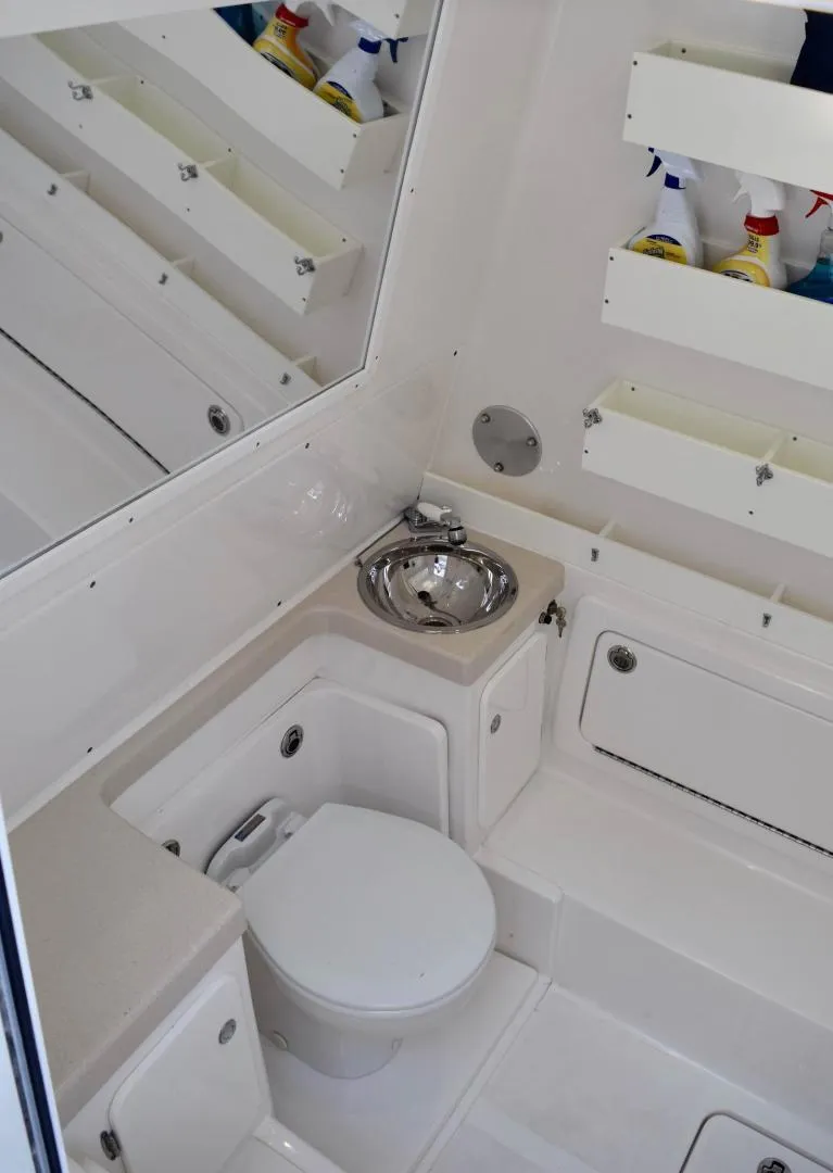 Slide: The Image of 2014 Invincible Open Fisherman boat bathroom with toilet and sink. - 13