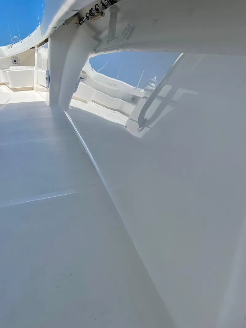 Slide: The Image of 2014 Invincible 42 Open Fisherman boat deck with sleek white finish and clear blue sky. - 16