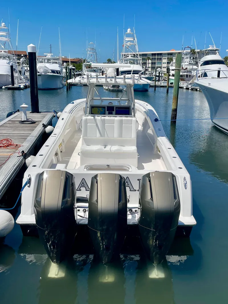 Slide: The Image of 2014 Invincible 42 Open Fisherman boat docked with triple outboard engines. - 18