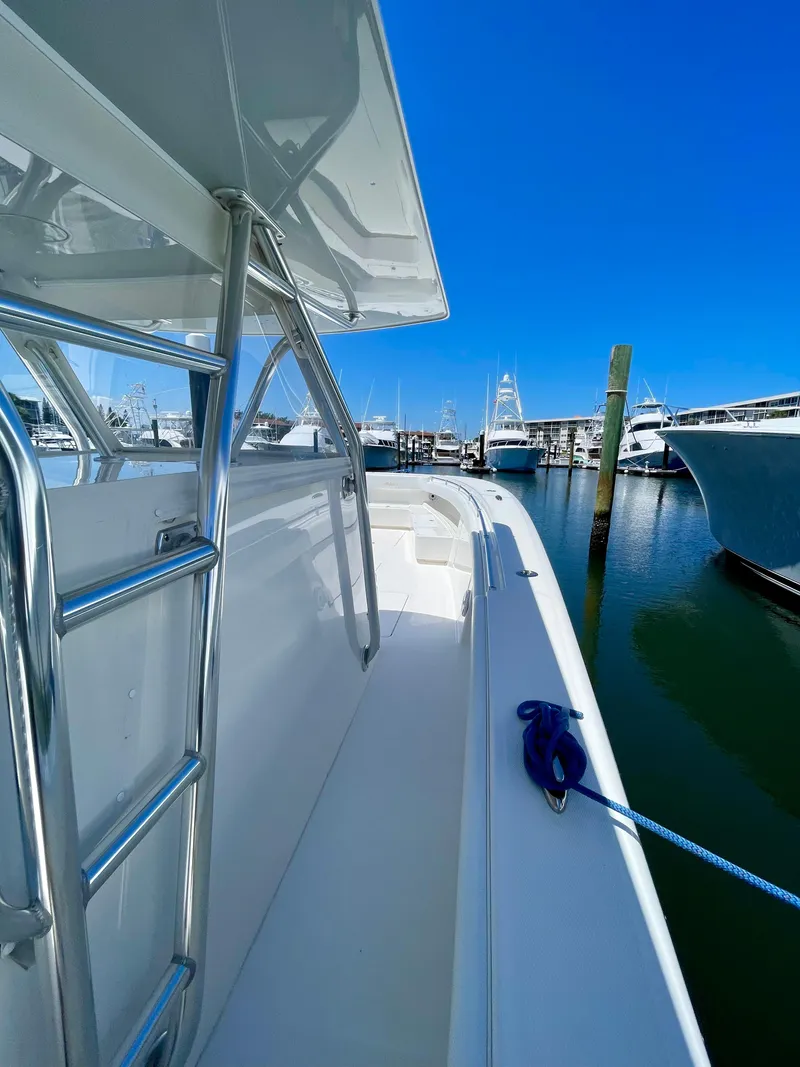 Slide: The Image of 2014 Invincible 42 Open Fisherman boat docked in a marina under clear blue skies. - 3
