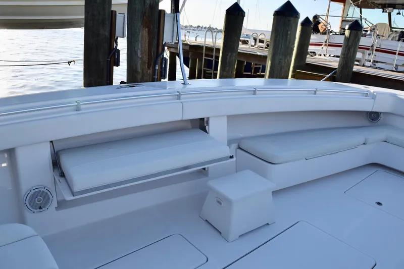 Slide: The Image of 2014 Invincible Open Fisherman boat interior with seating and storage, docked by wooden posts. - 8