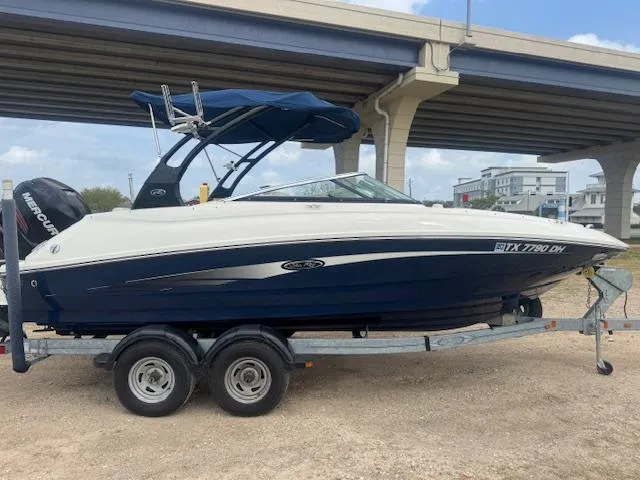 Slide: The Image of 2014 Sea Ray 220 SD Outboard boat on trailer under bridge. - 1