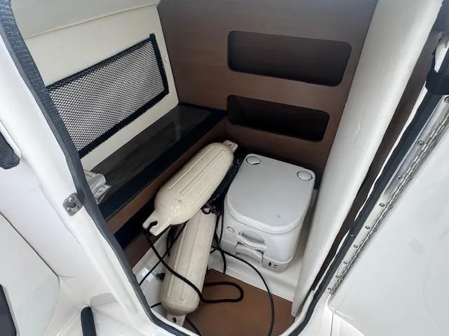 Slide: The Image of Interior of 2014 Sea Ray 220 SD Outboard with portable toilet and storage. - 11