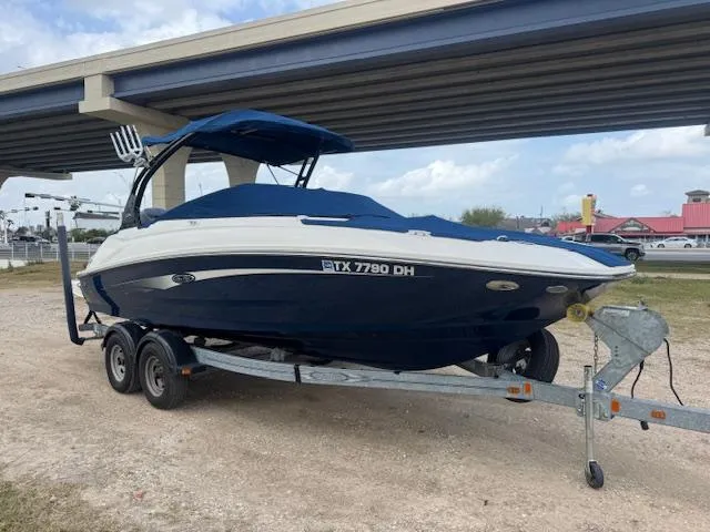Slide: The Image of 2014 Sea Ray 220 SD Outboard boat on trailer under bridge, blue and white design. - 5