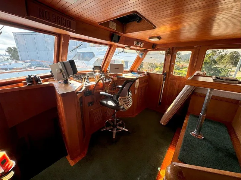 Slide: The Image of Pilothouse interior of 1980 Ocean Alexander 50 MK1 yacht, featuring wood paneling and navigation equipment. - 15