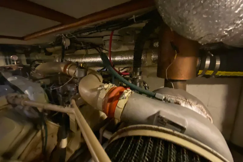 Slide: The Image of Engine room of 1980 Ocean Alexander 50 MK1 yacht, showcasing mechanical components and piping. - 84