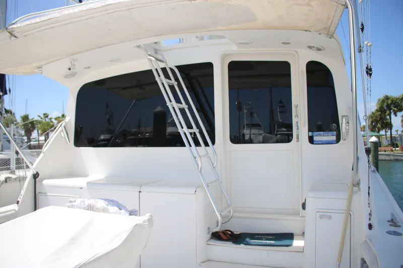 Slide: The Image of 1999 Ocean Yachts model yacht with white exterior and ladder, docked at a marina. - 19