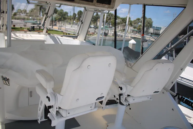Slide: The Image of 1999 Ocean Yachts model yacht interior with white captain chairs and marina view. - 27