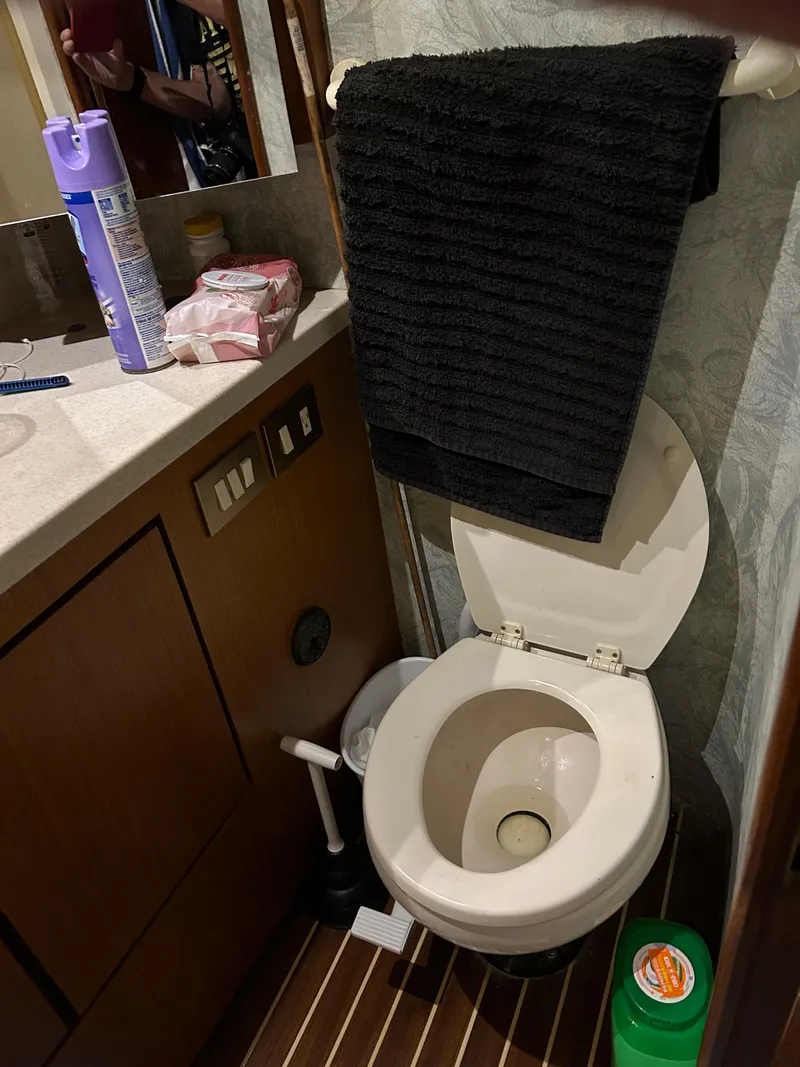 Slide: The Image of Bathroom inside a 1999 Ocean Yachts model, featuring a toilet and countertop essentials. - 46