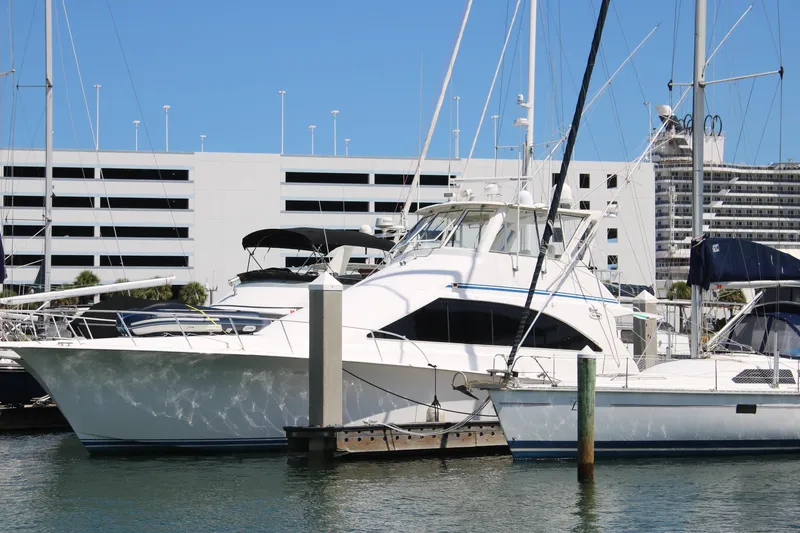 The Image of 1999 Ocean Yachts model docked at marina, surrounded by other boats and modern buildings. - 1