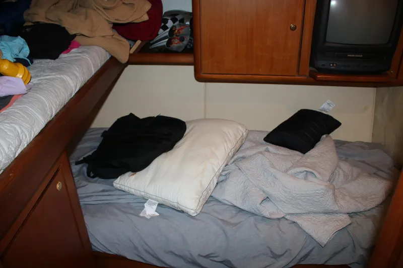 Slide: The Image of Cozy cabin interior of a 1999 Ocean Yachts model, featuring a bed and storage. - 10