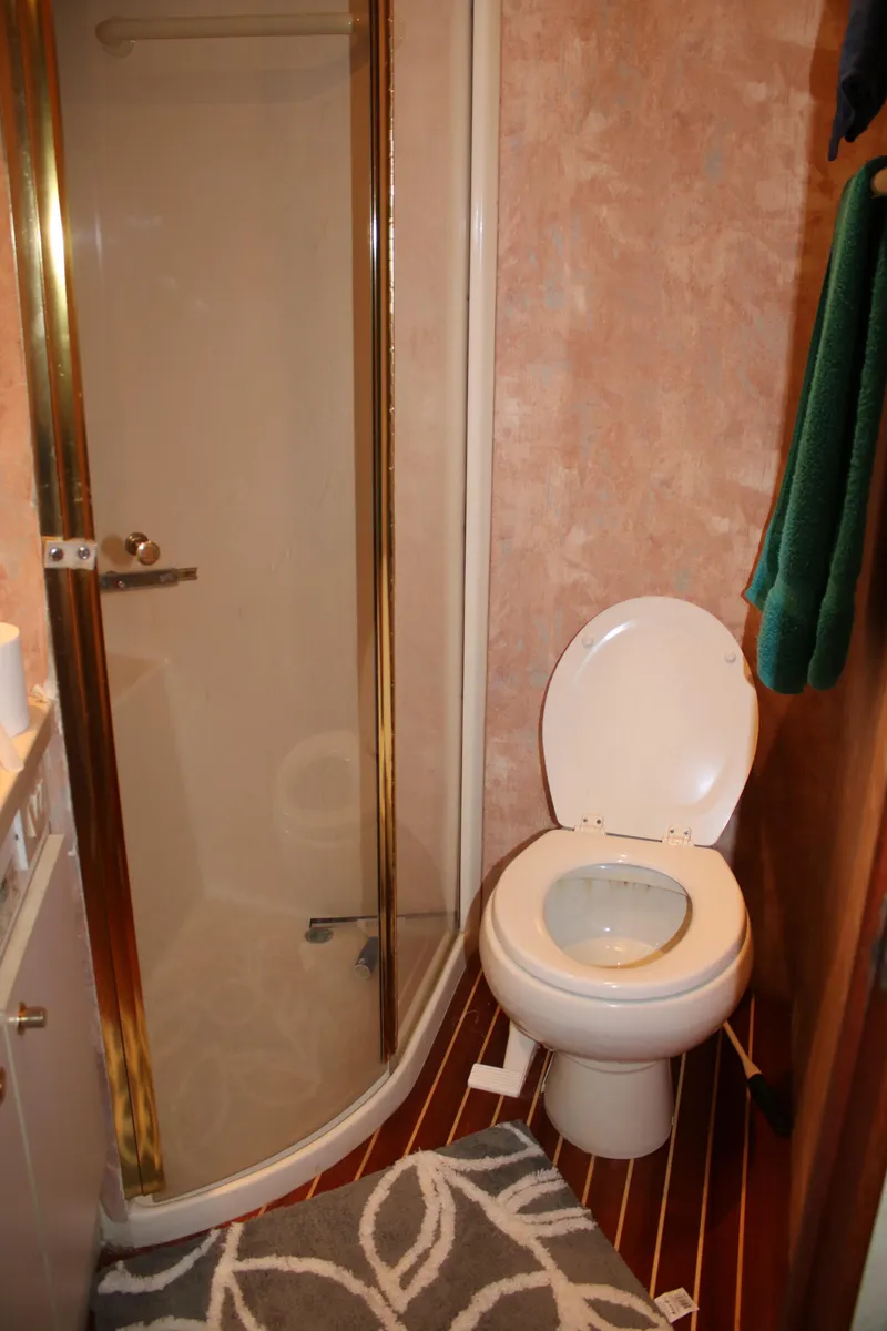 Slide: The Image of Bathroom interior of a 1999 Ocean Yachts model, featuring a shower and toilet. - 12