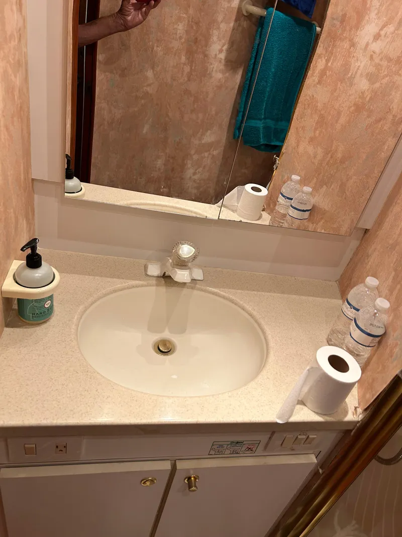 Slide: The Image of Bathroom sink area in a 1999 Ocean Yachts model, featuring toiletries and a mirror. - 48