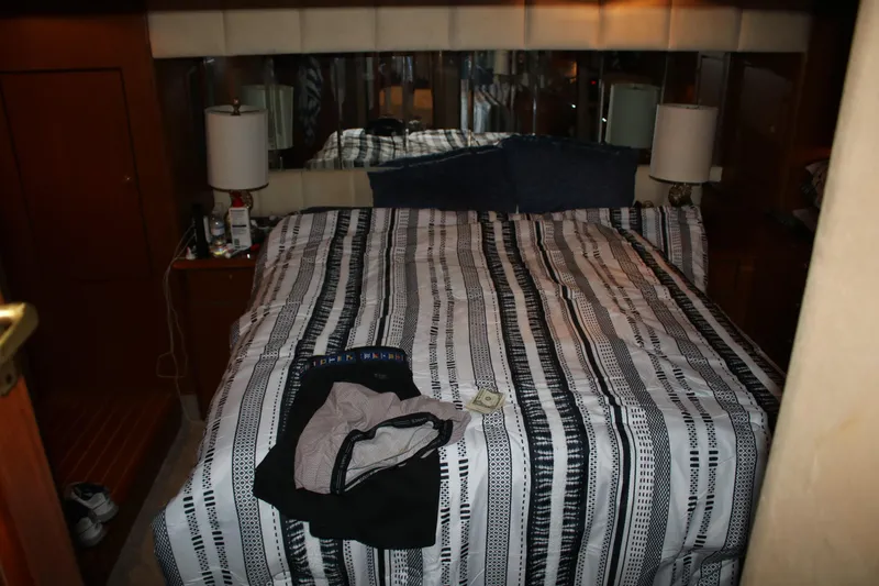 Slide: The Image of 1999 Ocean Yachts bedroom with striped bedding and bedside lamps. - 5