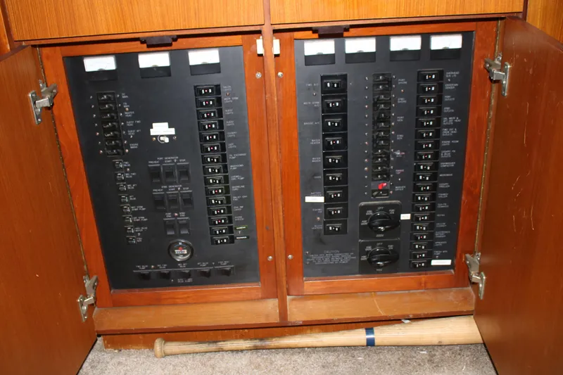 Slide: The Image of Electrical panel inside a 1999 Ocean Yachts model, with open wooden cabinet doors. - 9