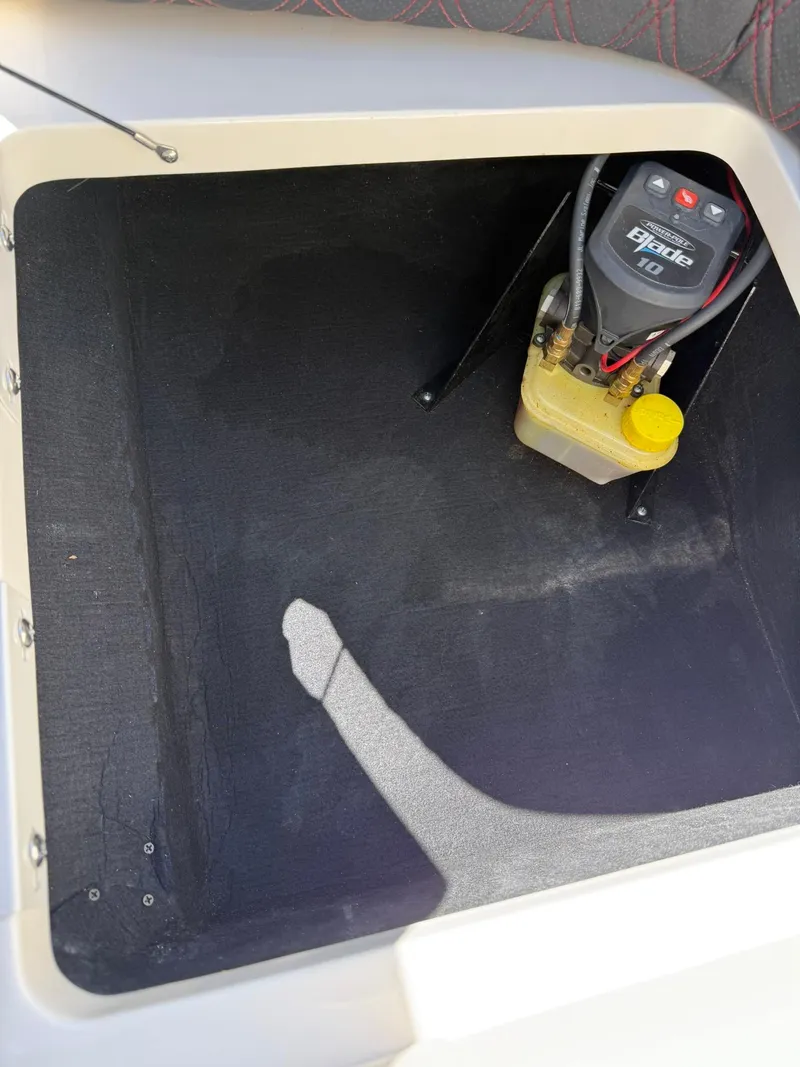 Slide: The Image of 2019 Bennington 25 QX Sport storage compartment with battery and wiring. - 38