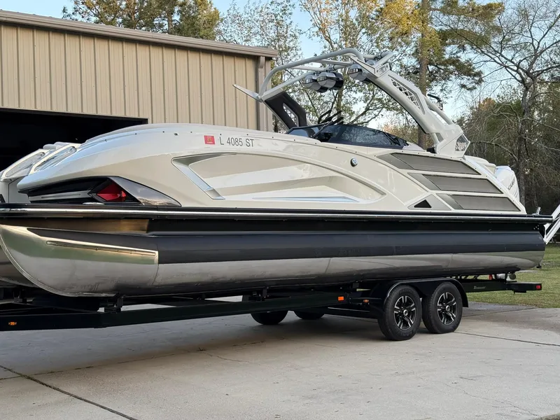 Slide: The Image of 2019 Bennington 25 QX Sport pontoon boat on trailer, parked near a building. - 4
