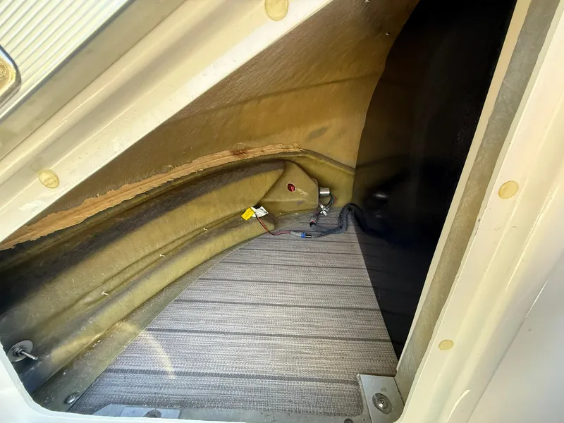 Slide: The Image of Storage compartment in a 2019 Bennington 25 QX Sport boat, featuring carpeted flooring. - 40