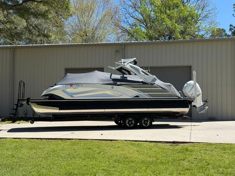 Slide: The Image of 2019 Bennington 25 QX Sport boat on trailer, parked outside a metal building. - 41