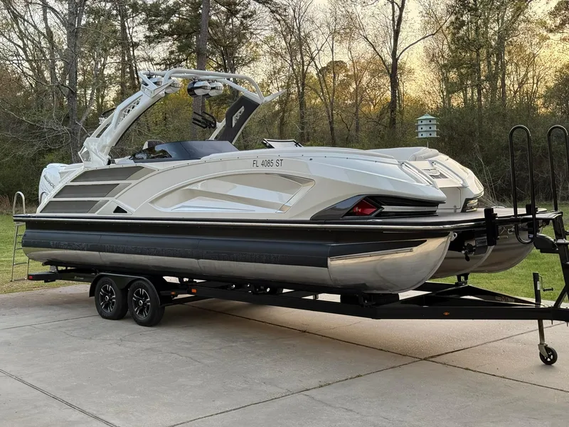 Slide: The Image of 2019 Bennington 25 QX Sport pontoon boat on trailer, parked outdoors. - 5
