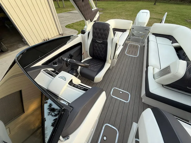 Slide: The Image of 2019 Bennington 25 QX Sport boat interior with luxurious seating and modern dashboard. - 9