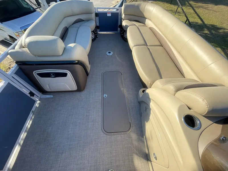 Slide: The Image of 2017 Regency 220 DL3 pontoon boat interior with beige seating and carpeted floor. - 12