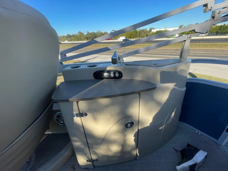 Slide: The Image of 2017 Regency 220 DL3 boat interior with storage cabinet and cup holders. - 17