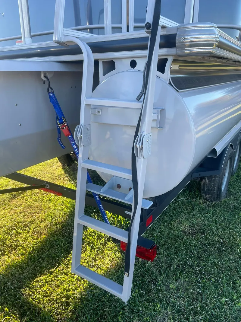 Slide: The Image of 2017 Regency 220 DL3 pontoon boat ladder on grassy area. - 19