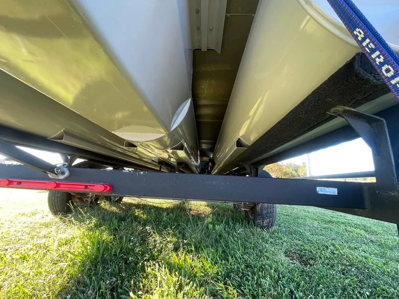 Slide: The Image of Underneath view of a 2017 Regency 220 DL3 pontoon boat on a trailer. - 32