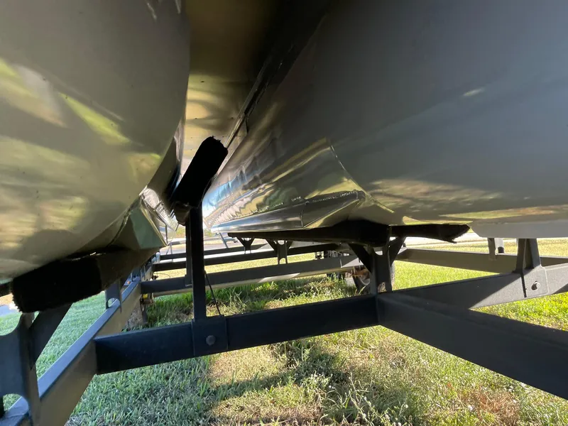 Slide: The Image of Underneath view of a 2017 Regency 220 DL3 pontoon boat on a trailer. - 33