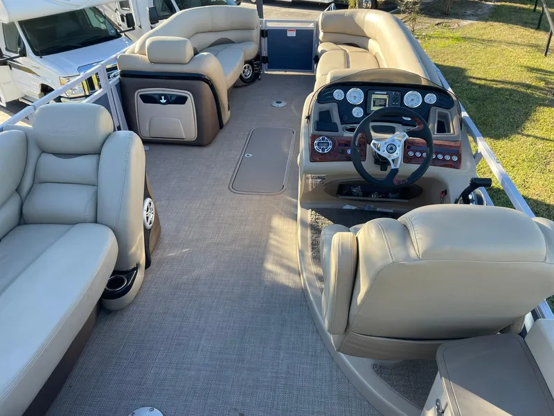 Slide: The Image of 2017 Regency 220 DL3 pontoon boat interior with beige seating and modern dashboard. - 4