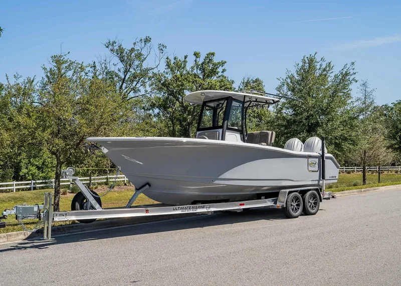 Slide: The Image of 2025 Sea Hunt Gamefish 25 boat on trailer, parked on a sunny road. - 1