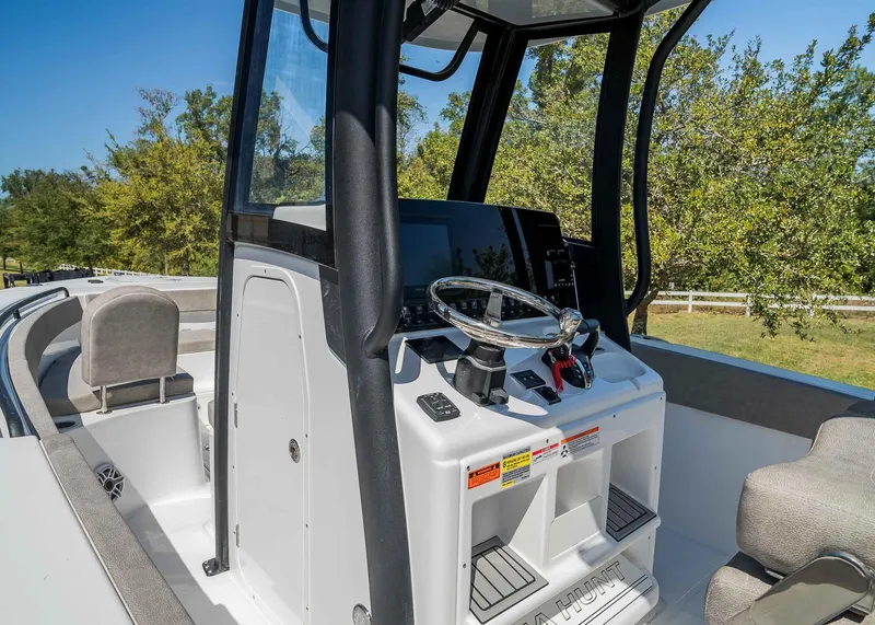 Slide: The Image of 2025 Sea Hunt Gamefish 25 boat interior with steering console and seating. - 12