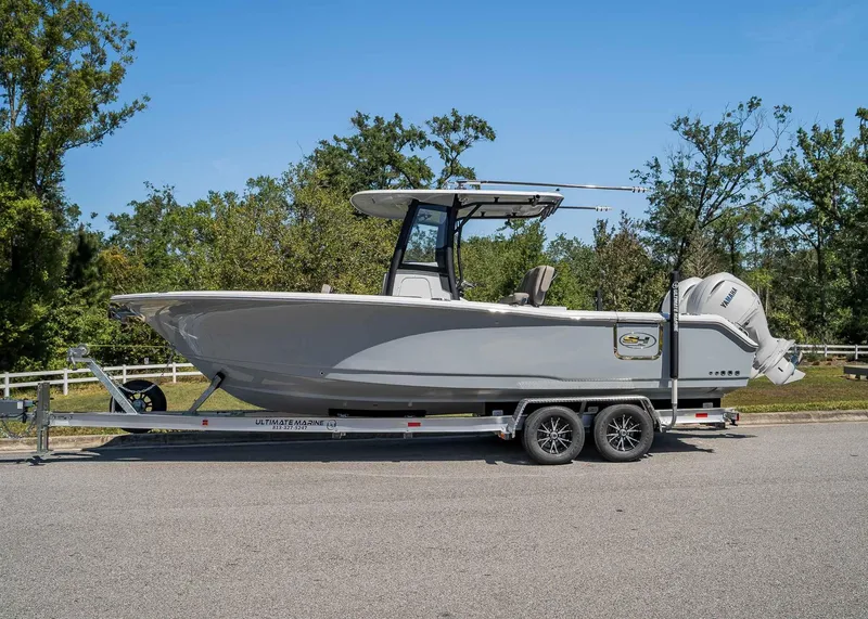 Slide: The Image of 2025 Sea Hunt Gamefish 25 boat on trailer, parked outdoors, side view. - 2