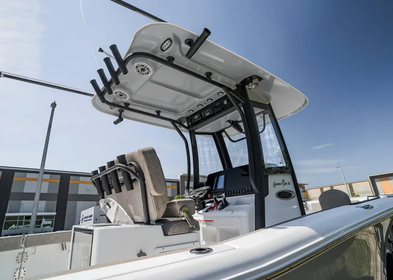 Slide: The Image of 2025 Sea Hunt Gamefish 25 boat console with rod holders and electronics under clear sky. - 20