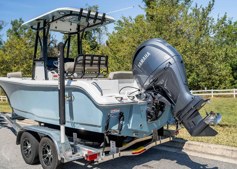 Slide: The Image of 2025 Sea Hunt Ultra 219 boat on trailer with Yamaha outboard motor, parked outdoors. - 4