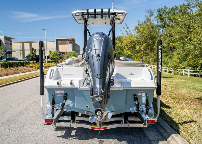 Slide: The Image of 2025 Sea Hunt Ultra 219 boat with powerful outboard motor, parked on a sunny street. - 5