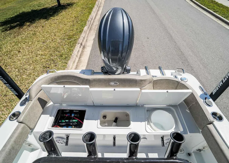 Slide: The Image of 2025 Sea Hunt Ultra 219 boat with open storage compartments and rod holders. - 8