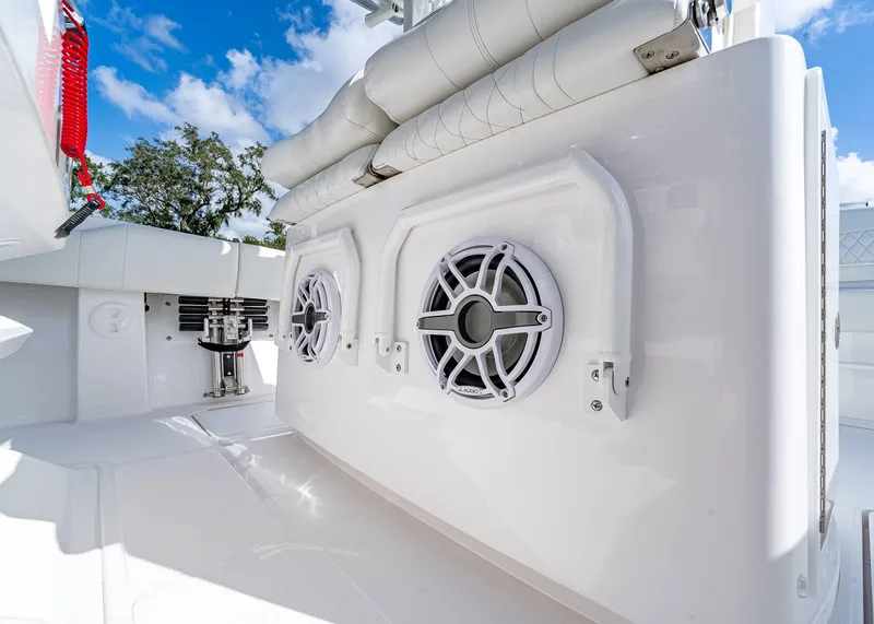Slide: The Image of 2026 Fountain 38 TE boat interior with speakers and seating, under a clear blue sky. - 20