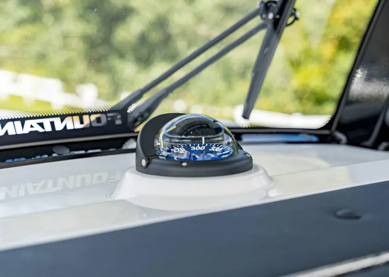 Slide: The Image of Compass on 2026 Fountain 38 TE boat dashboard, with windshield wiper in background. - 27