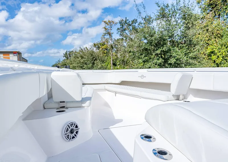 Slide: The Image of 2026 Fountain 38 TE boat interior with white seating and speaker, under a blue sky. - 33