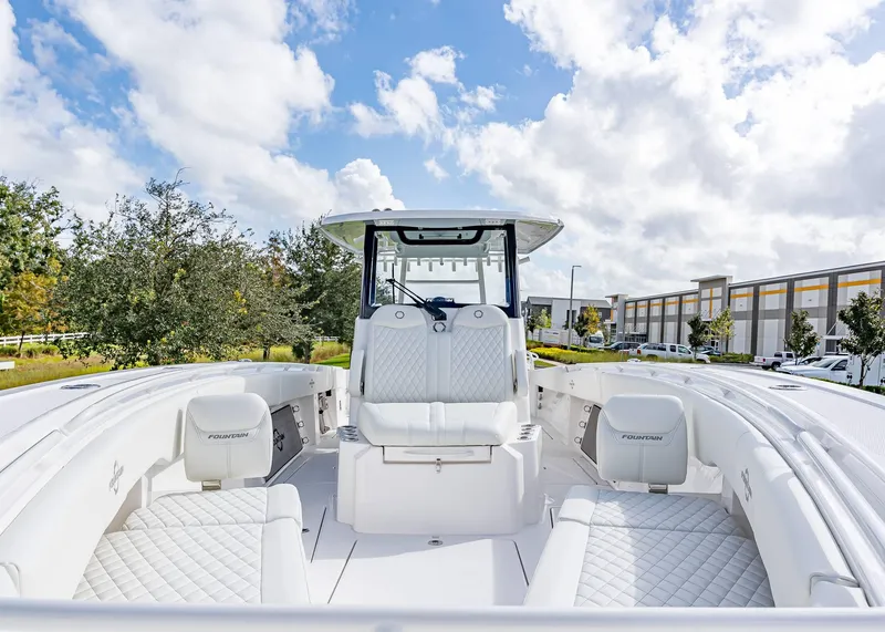 Slide: The Image of 2026 Fountain 38 TE boat with white interior, parked outdoors under a cloudy sky. - 34