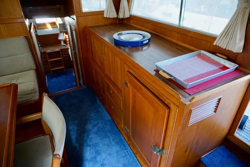 Slide: The Image of 1982 Grand Banks Classic yacht interior with wooden cabinetry and nautical-themed decor. - 13