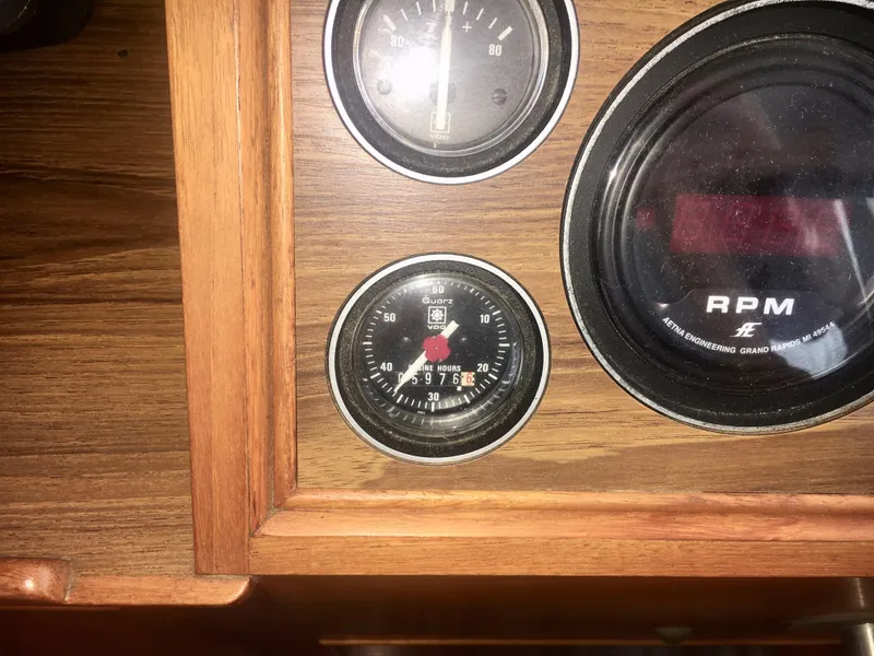 Slide: The Image of 1982 Grand Banks Classic dashboard with RPM and hour gauges in wooden panel. - 50